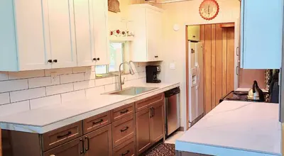 a kitchen with white cabinets and a sink at Lakeview Lodge, bookable boat slip! in Bass Lake