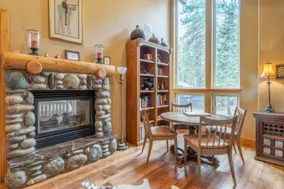 a living room with a fireplace and a table and chairs at North Shore - Forest Haven in Kings Beach