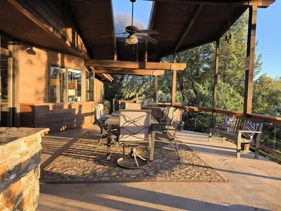 a porch of a house with chairs and a ceiling fan at Mountain Oasis-Indoor Hot Tub, Game Room, VIEWS in Oakhurst