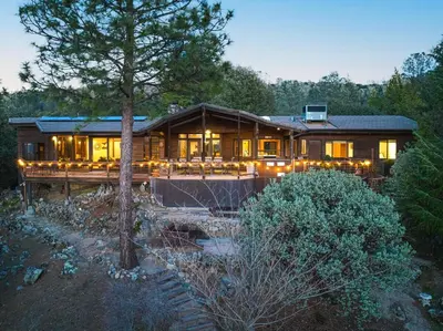 a large wooden house with lights on it at Mountain Oasis-Indoor Hot Tub, Game Room, VIEWS in Oakhurst