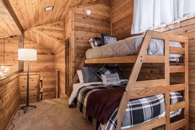 a bedroom with two bunk beds in a log cabin at Spacious 3BD & Loft Villa - Convenient to Slopes in Mammoth Lakes