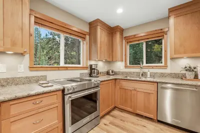 a kitchen with wooden cabinets and stainless steel appliances at Woodlands House home in Truckee