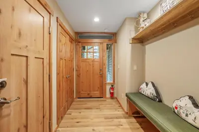 a hallway with a green bench and a wooden door at Woodlands House home in Truckee