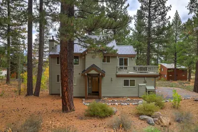 a house in the woods with a tree at Woodlands House home in Truckee