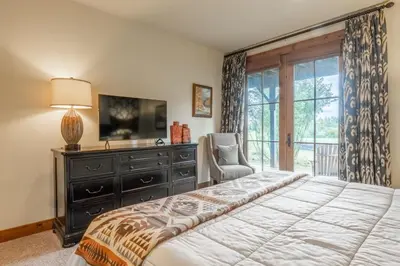a bedroom with a bed and a dresser and a television at Lodges 1178 - Timber Lodge Retreat in Mammoth Lakes