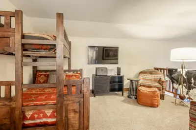 a bedroom with two bunk beds and a desk at Lodges 1178 - Timber Lodge Retreat in Mammoth Lakes