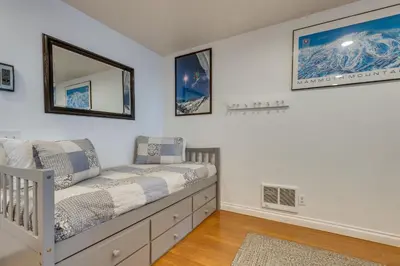 a bedroom with a crib and a mirror on the wall at Mammoth Mtn Ski-InandOut Condo with Hot Tub Access! in Mammoth Lakes