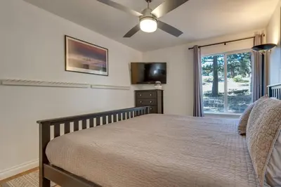 a bedroom with a bed with a ceiling fan and a window at Mammoth Mtn Ski-InandOut Condo with Hot Tub Access! in Mammoth Lakes