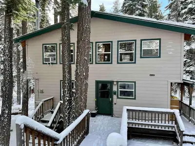 a house with a green door and benches in the snow at Palisades, Lake Tahoe, Tahoe City, Hot Tub, Dogs OK in Tahoe City