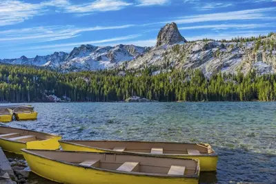 three boats on the shore of a lake with mountains at Hidden Valley 29 D in Mammoth Lakes