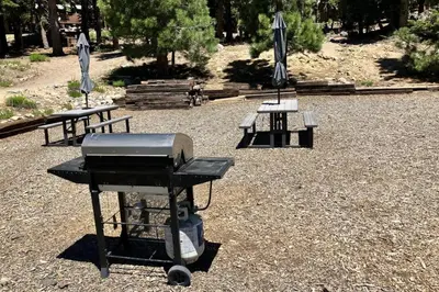 a bbq grill and two picnic tables with umbrellas at Hidden Valley 39 E in Mammoth Lakes