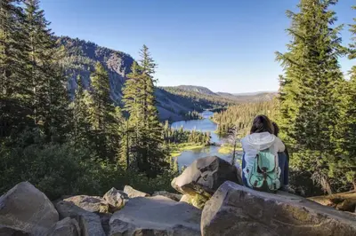 a woman sitting on a rock overlooking a lake at Hidden Valley 39 E in Mammoth Lakes
