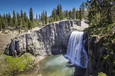 a waterfall on the side of a mountain with trees at Hidden Valley 39 E in Mammoth Lakes