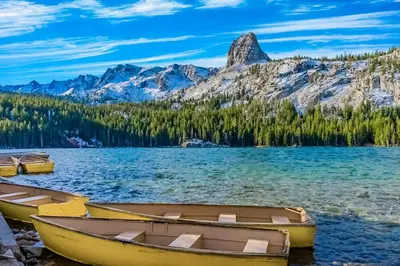 two boats on the shore of a lake with mountains at Mammoth Green 116 in Mammoth Lakes