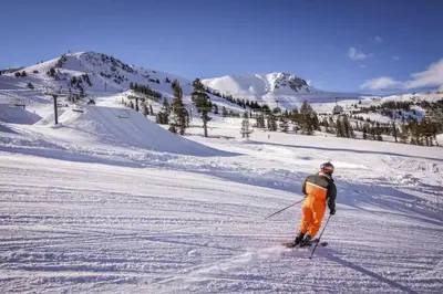 a man is skiing down a snow covered slope at Hidden Valley 30 D in Mammoth Lakes