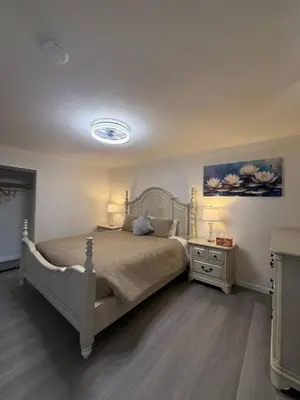 a bedroom with a bed and a nightstand with two lamps at Newly Renovated Lakefront with Dock in Bethel Island