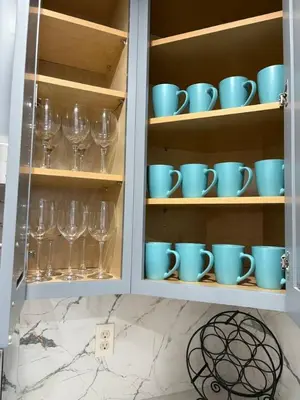 a cabinet filled with blue cups and wine glasses at Newly Renovated Lakefront with Dock in Bethel Island