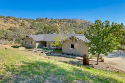 a house on a hill with a tree at Scenic Yosemite Lakes Escape with Community Perks! in Coarsegold
