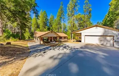 a house with a driveway with a garage at The Lady Bug Family Retreat in Mariposa