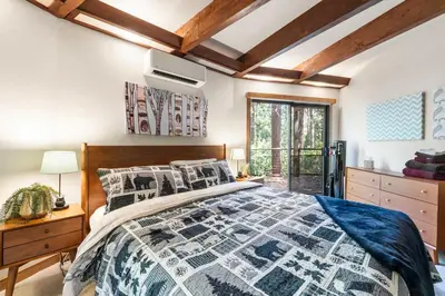 a bedroom with a bed with a blue and white quilt at Tranquil Treehouse near Fly-In Lake with Deck Dining & BBQ in Arnold