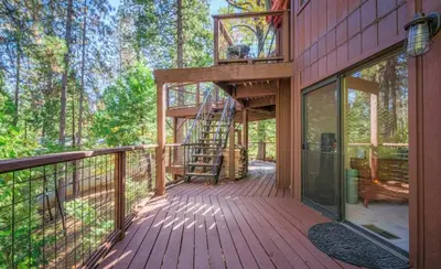 a house being constructed on a deck with a ladder at Tranquil Treehouse near Fly-In Lake with Deck Dining & BBQ in Arnold