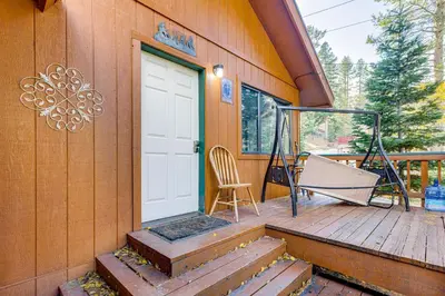 a porch with a white door and a chair at 1 Mi to Skiing! Cabin Hideaway on June Lake Loop in June Lake