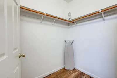 a closet with a white wall and a wooden floor at Extended-Stay Ready! Elk Grove Unit with Pool Access in Elk Grove