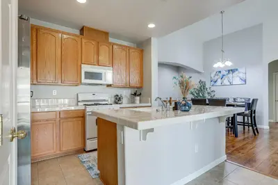 a kitchen with wooden cabinets and a kitchen island at Extended-Stay Ready! Elk Grove Unit with Pool Access in Elk Grove
