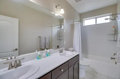 a white bathroom with two sinks and a tub at Family-Friendly Retreat with Playground in Reno! in Reno