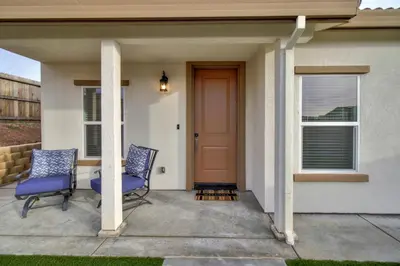 two chairs on a porch with a red door at Modern Cozy and contemporary in Ione