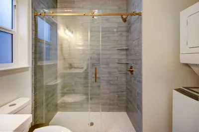a bathroom with a glass shower with a toilet at Modern Cozy and contemporary in Ione