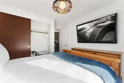 a bedroom with a bed with a tv on the wall at Family 4BR Home with Patio by Willowcreek Park in Sparks