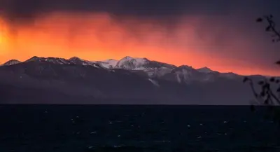 a sunset over a mountain range with the sky at Tahoe Edgelake Beach Club by Coolvacay in Tahoe Vista