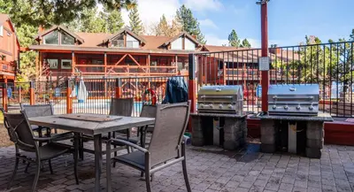 a patio with a table and two bbqs and a house at Tahoe Edgelake Beach Club by Coolvacay in Tahoe Vista