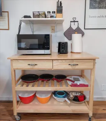 a microwave on top of a wooden cart with dishes at (A108) Studio Condominiums in Yosemite West