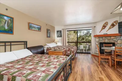 a hotel room with two beds and a fireplace at (A108) Studio Condominiums in Yosemite West