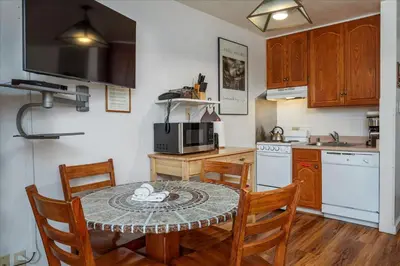 a kitchen with a table and chairs and a kitchen with a microwave at (A108) Studio Condominiums in Yosemite West