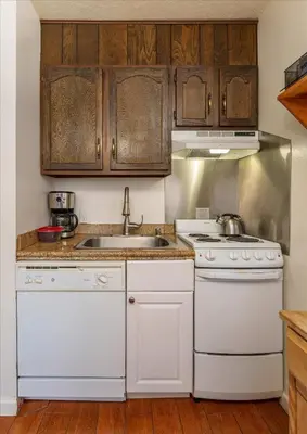 a kitchen with white appliances and wooden cabinets at (A109) Studio Condominiums in Yosemite West