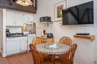 a kitchen with a table with chairs and a television at (A202) Loft Condominiums in Yosemite West
