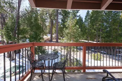 two chairs and a table on a porch with trees at (A204) Loft Condominiums in Yosemite West