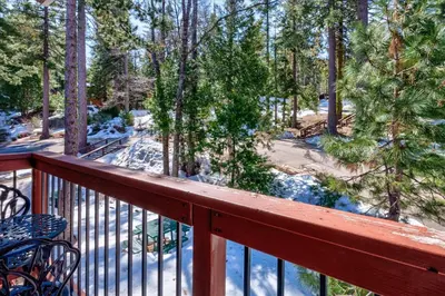a balcony with a view of a snow covered forest at (A204) Loft Condominiums in Yosemite West