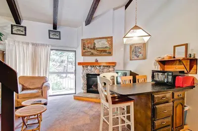 a living room with a table and a fireplace at (A203) Loft Condominiums in Yosemite West