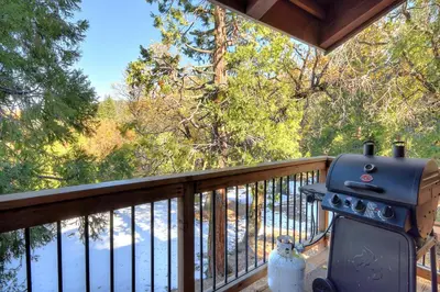 a grill on a deck with a view of the water at (A207) Loft Condominiums in Yosemite West