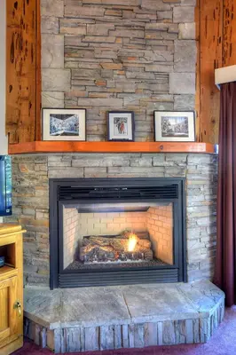 a stone fireplace with a fire in it at (A207) Loft Condominiums in Yosemite West
