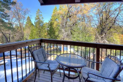 two chairs and a table on a deck with snow at (A211) Loft Condominiums in Yosemite West