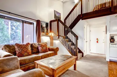 a living room with a couch and a stair case at (B207) Loft Condominiums in Yosemite West
