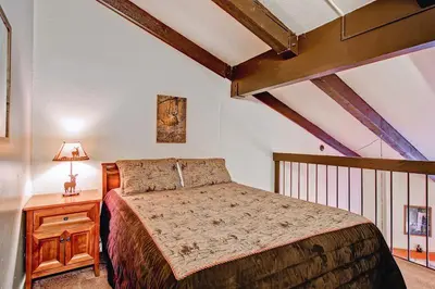 a bedroom with a bed and a table with a lamp at (B211) Loft Condominiums in Yosemite West