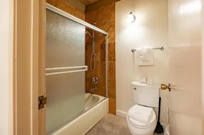 a bathroom with a toilet and a glass shower at Creekside Chalet Stay for 6 in Kings Beach