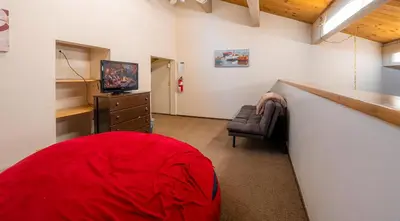 a room with a red bean bag chair and a television at Creekside Chalet Stay for 6 in Kings Beach