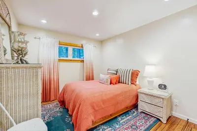 a bedroom with a bed with orange sheets and a window at Colorado Pines Retreat in South Lake Tahoe